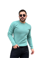 A man wearing a long-sleeved mint green sweater and sunglasses. Bezurvan.com